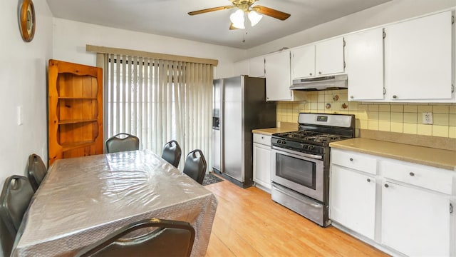 kitchen with backsplash, white cabinets, ceiling fan, light wood-type flooring, and stainless steel appliances