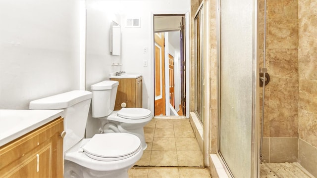 bathroom with tile patterned floors, vanity, toilet, and walk in shower