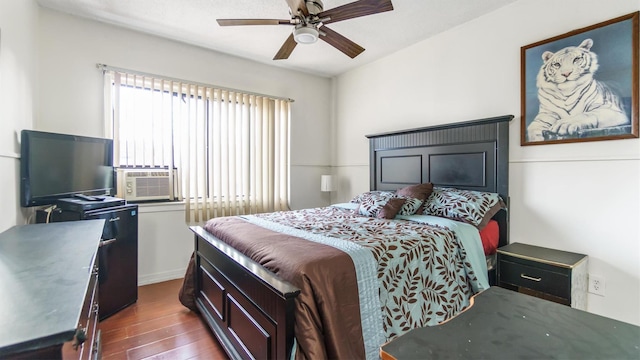 bedroom featuring ceiling fan, cooling unit, and dark hardwood / wood-style floors