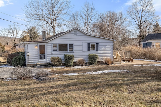 view of front of home with a wooden deck and a front lawn