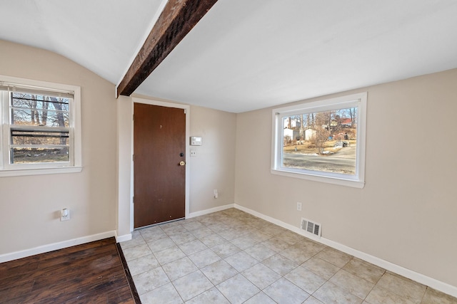 foyer featuring vaulted ceiling with beams and light tile patterned floors