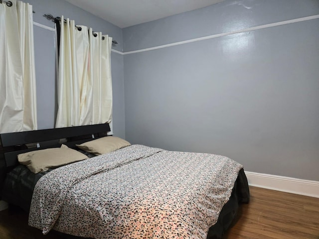 bedroom with dark wood-type flooring