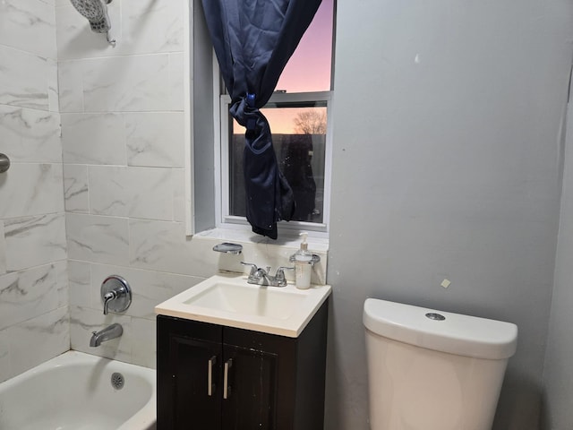 full bathroom featuring toilet, vanity, and tiled shower / bath