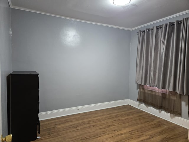 spare room featuring dark hardwood / wood-style floors and ornamental molding