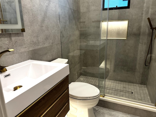 bathroom featuring an enclosed shower, vanity, toilet, and tile walls