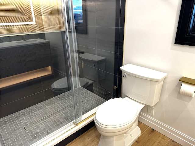 bathroom featuring hardwood / wood-style floors, toilet, and an enclosed shower