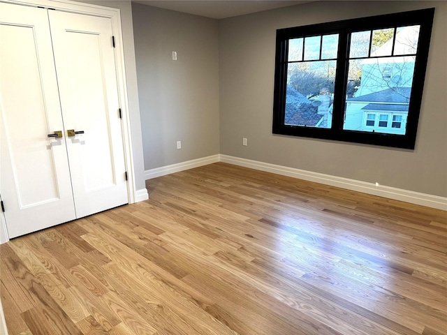 unfurnished bedroom featuring light hardwood / wood-style floors and a closet