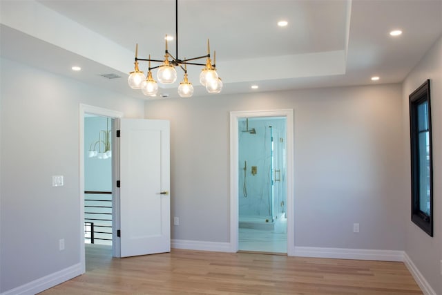 spare room featuring light hardwood / wood-style floors and an inviting chandelier