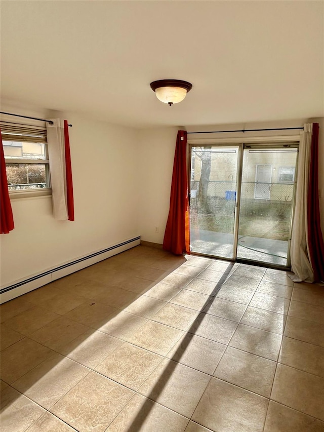 tiled spare room featuring baseboard heating