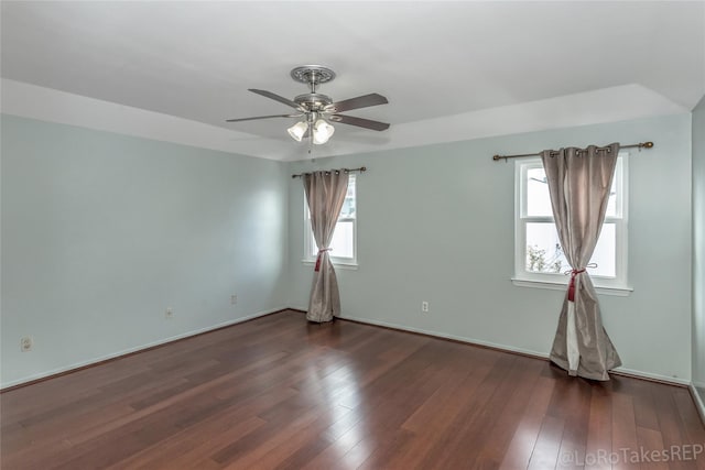 spare room featuring a wealth of natural light, dark wood-type flooring, and ceiling fan