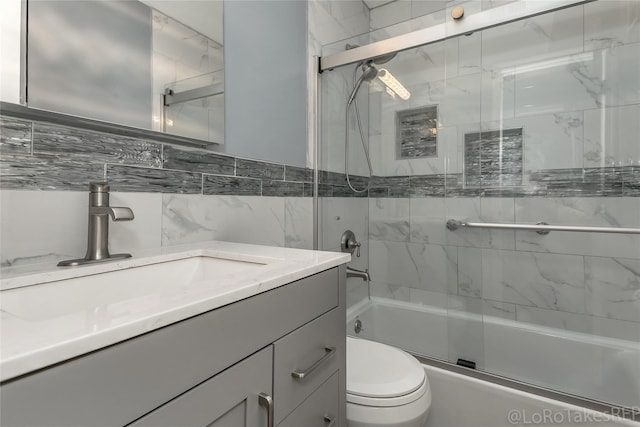 full bathroom featuring decorative backsplash, vanity, shower / bath combination with glass door, tile walls, and toilet