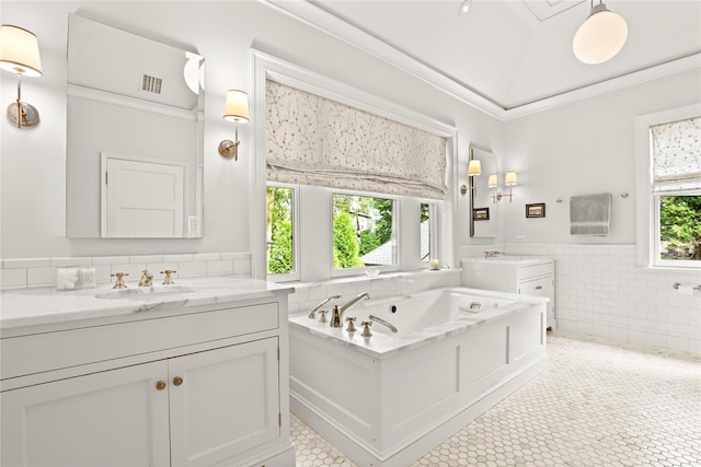 bathroom with tile patterned flooring, vanity, a healthy amount of sunlight, and tile walls