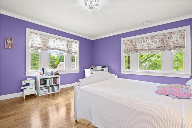 bedroom with hardwood / wood-style flooring and crown molding