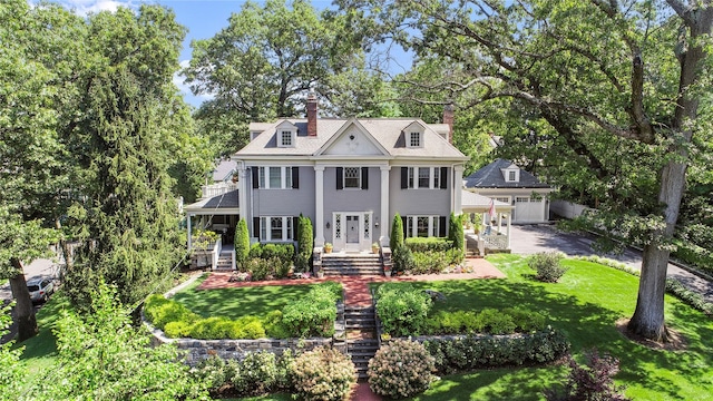 colonial house featuring a front lawn