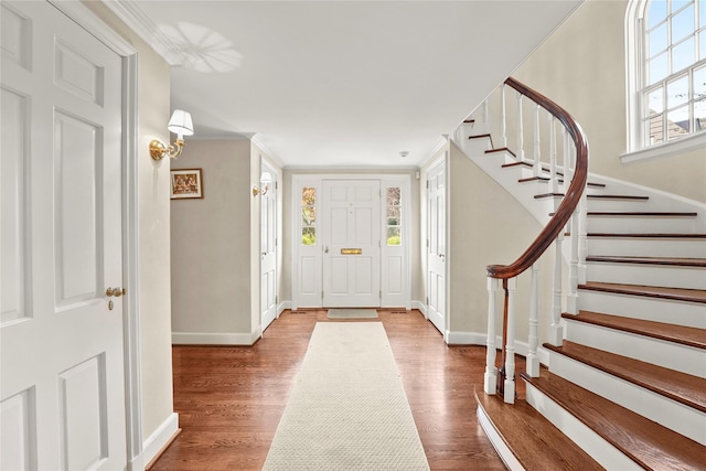 entrance foyer featuring wood-type flooring and ornamental molding