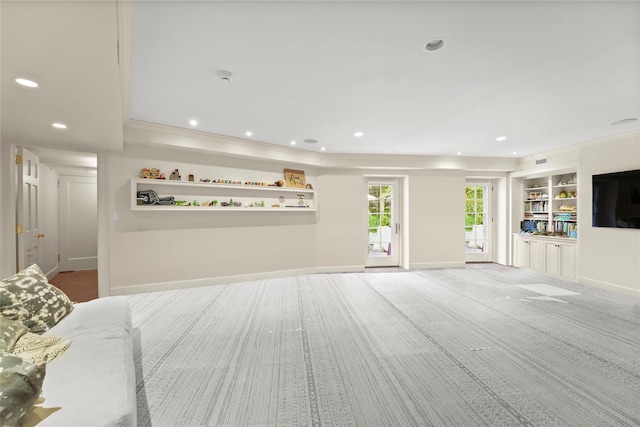 living room with built in shelves and ornamental molding