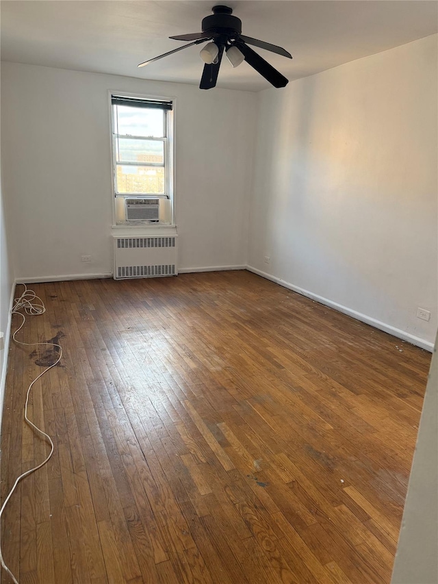 empty room featuring ceiling fan, radiator heating unit, cooling unit, and dark wood-type flooring