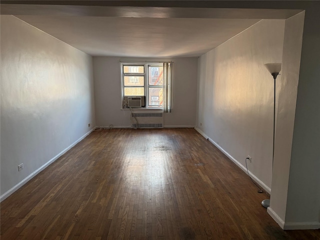 empty room with dark hardwood / wood-style floors and radiator heating unit