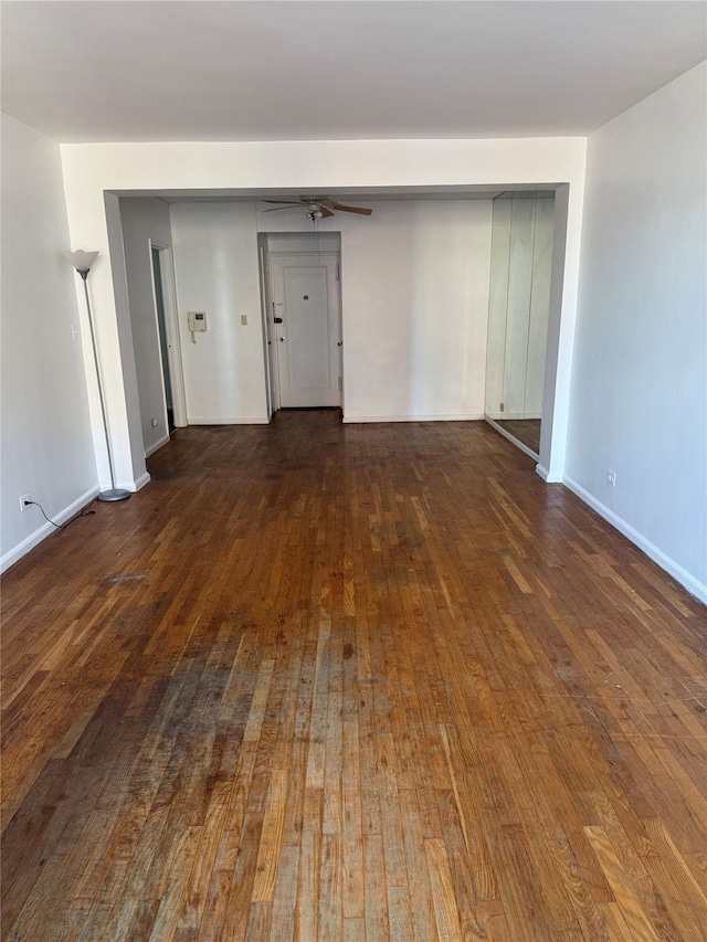 unfurnished room with ceiling fan and dark wood-type flooring