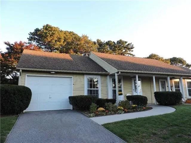 ranch-style home with a garage and a front lawn