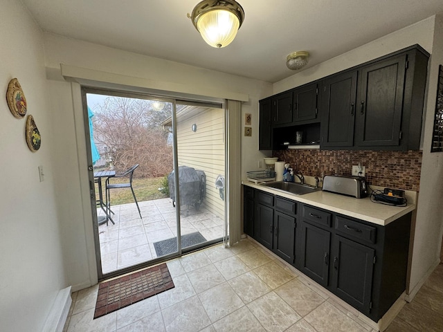 kitchen featuring light tile patterned floors, backsplash, and sink