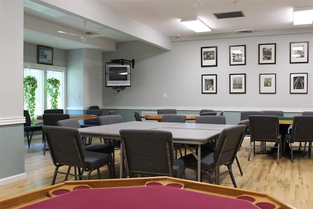 dining space with ceiling fan, beam ceiling, and wood-type flooring