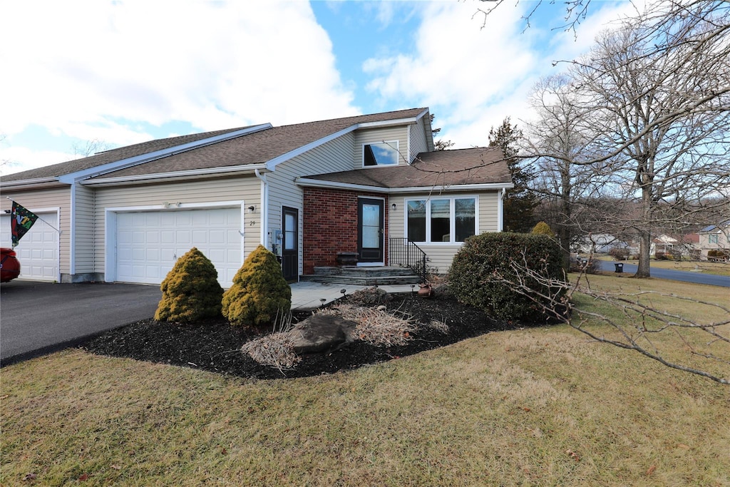 view of front of house with a garage and a front lawn