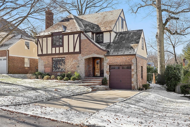 english style home featuring a garage