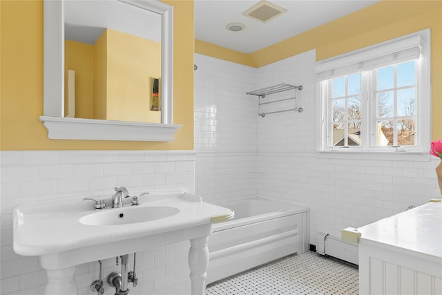 bathroom featuring shower / bathtub combination, baseboard heating, and tile walls