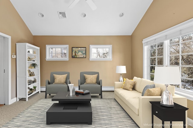 living room featuring a healthy amount of sunlight, lofted ceiling, and a baseboard heating unit