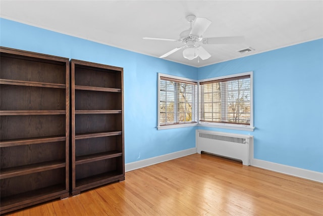 interior space with ceiling fan, light wood-type flooring, and radiator