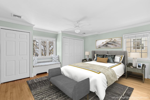 bedroom featuring multiple windows, hardwood / wood-style floors, ceiling fan, and ornamental molding