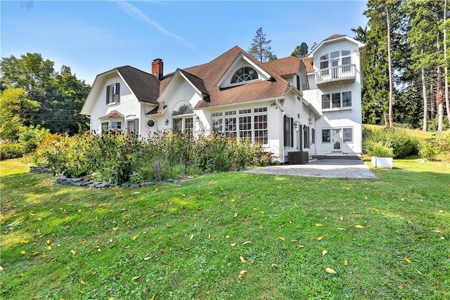 back of house featuring a yard, a patio area, and a balcony