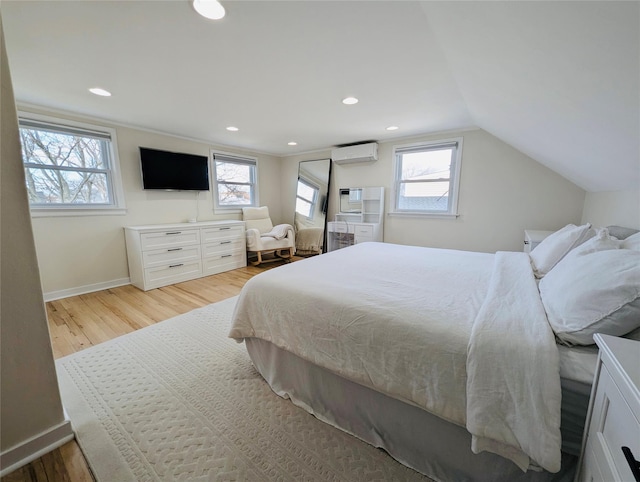 bedroom with vaulted ceiling, light hardwood / wood-style flooring, and a wall mounted AC