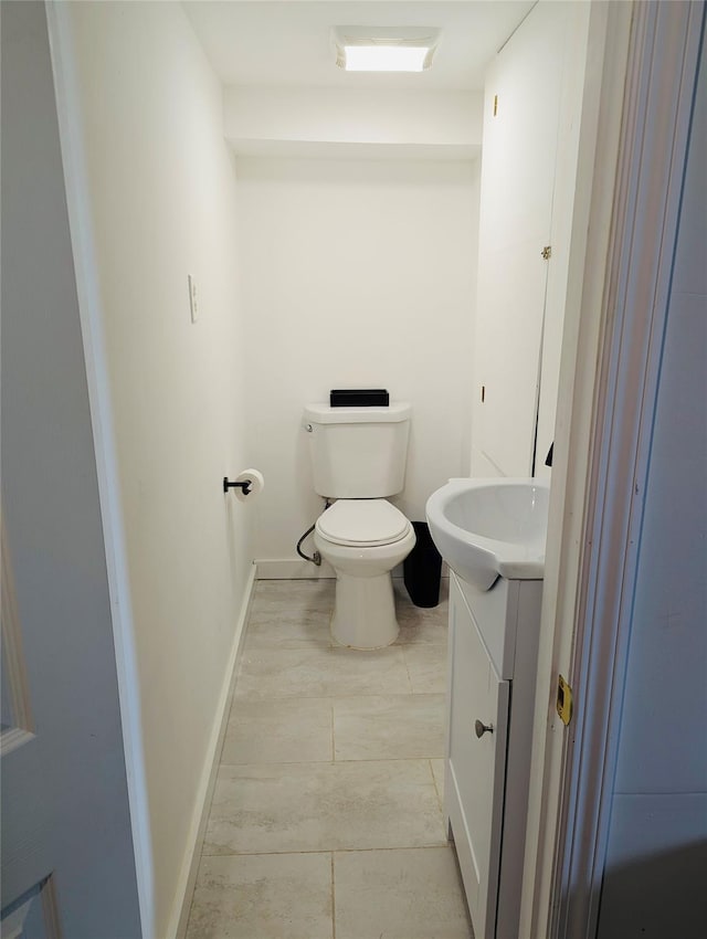 bathroom with tile patterned flooring, vanity, and toilet