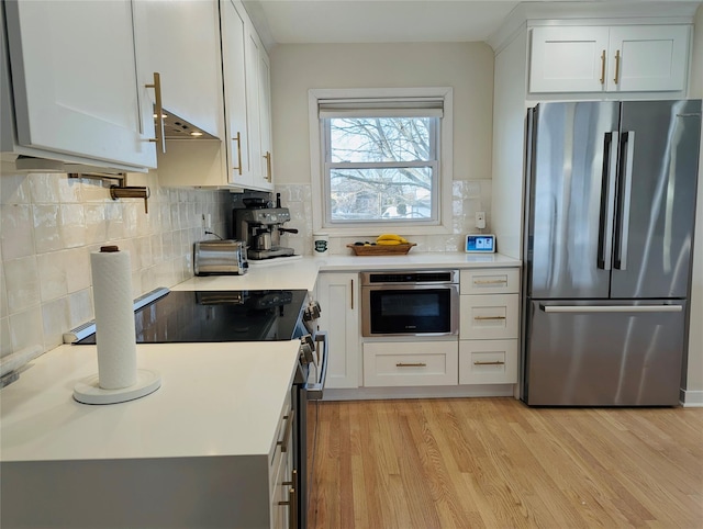 kitchen with white cabinetry, light hardwood / wood-style flooring, and stainless steel appliances