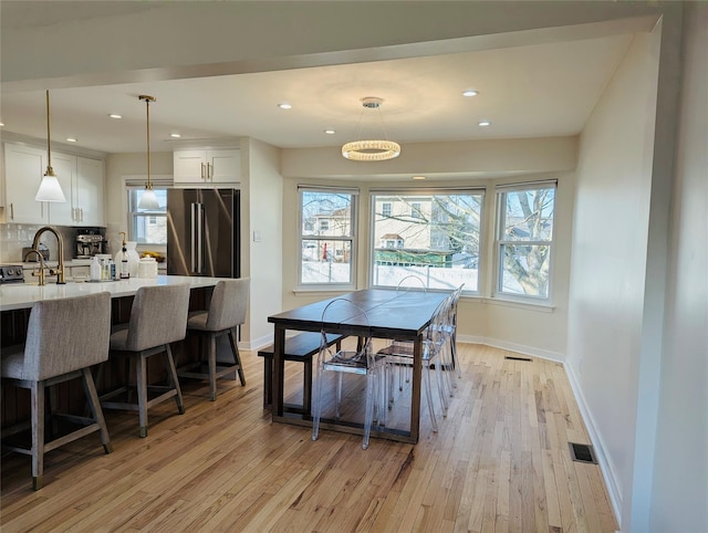 dining space featuring light hardwood / wood-style floors and sink