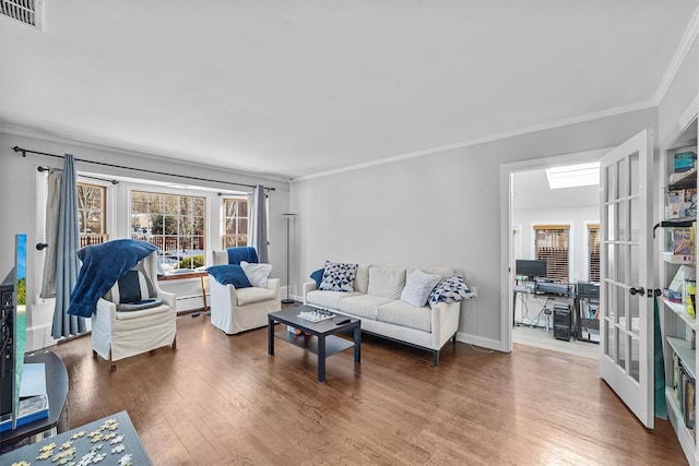 living room with ornamental molding, a baseboard heating unit, and hardwood / wood-style floors