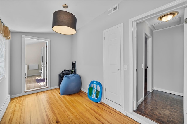 interior space with a baseboard heating unit and hardwood / wood-style floors