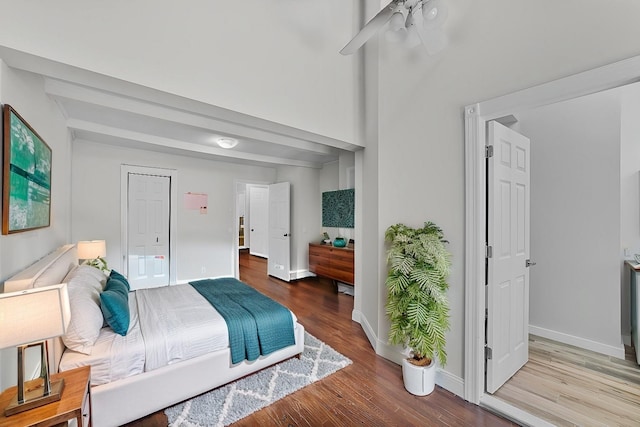 bedroom with a towering ceiling and wood-type flooring