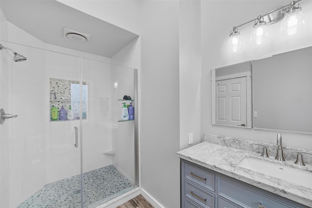 bathroom featuring vanity, a shower with shower door, and wood-type flooring