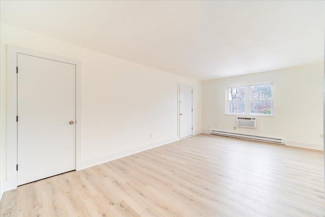 unfurnished room with a wall unit AC, light wood-type flooring, and a baseboard heating unit