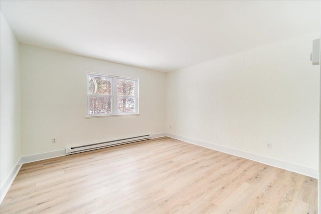 unfurnished room with a baseboard radiator and light wood-type flooring