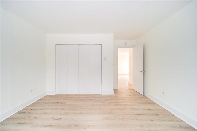 unfurnished bedroom featuring light hardwood / wood-style floors and a closet