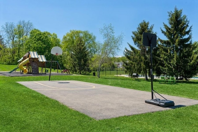 view of sport court featuring a lawn and a playground