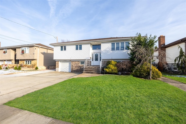 bi-level home featuring a garage and a front lawn