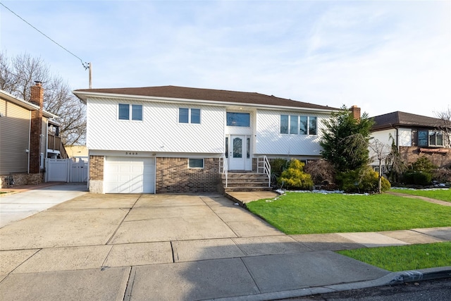 split foyer home featuring a garage and a front yard