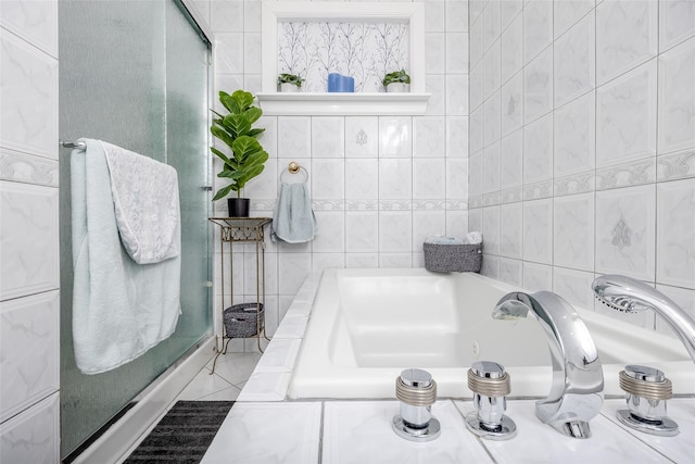 bathroom with a washtub and tile walls