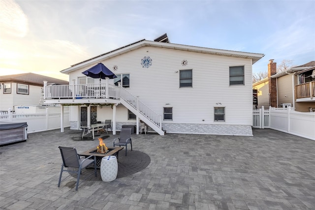 back house at dusk with a patio, a deck, and an outdoor fire pit