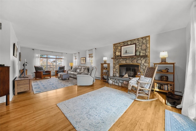 living room with hardwood / wood-style flooring, a fireplace, and a baseboard heating unit